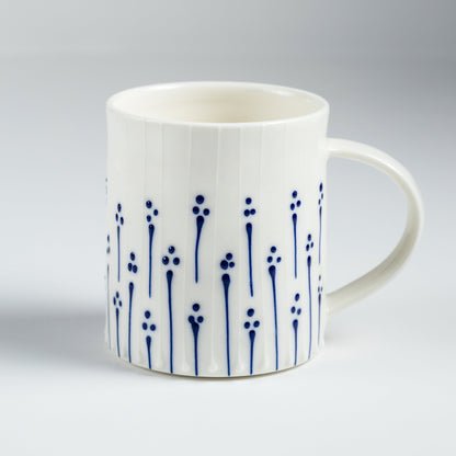 Handmade porcelain tea mug with blue slip-trailed flower pattern