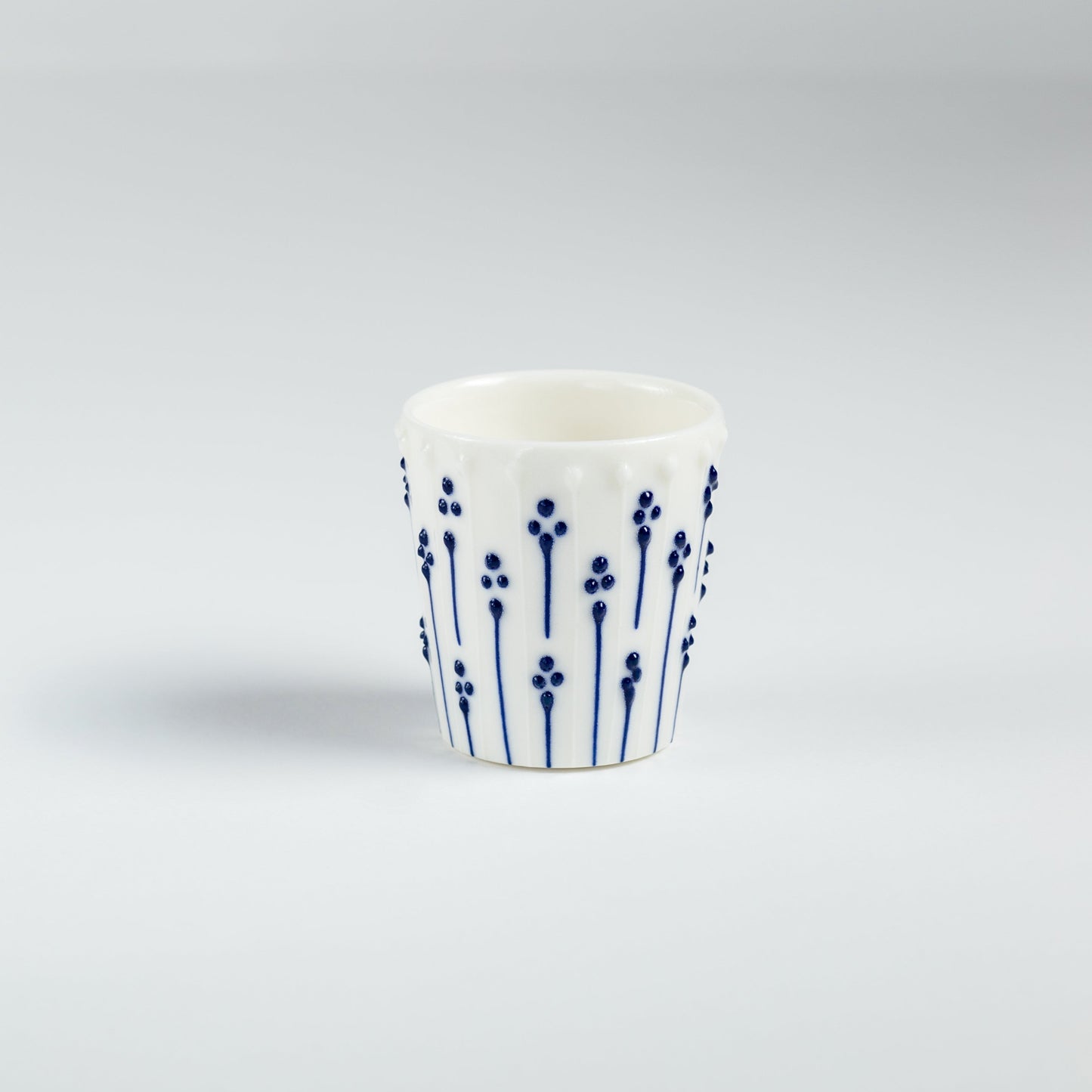 Handmade porcelain egg cups with blue slip-trailed flower patterns