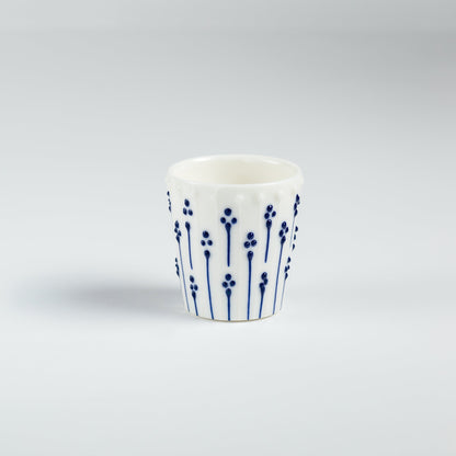 Handmade porcelain egg cups with blue slip-trailed flower patterns