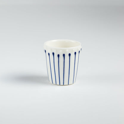 Handmade porcelain egg cups with blue slip-trailed line patterns