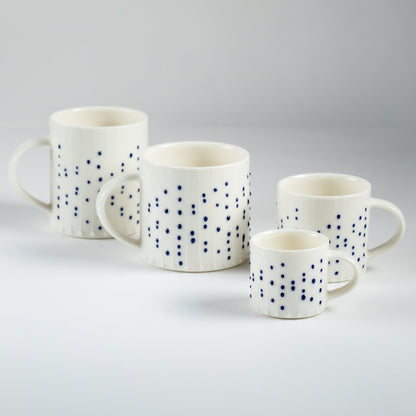 Handmade porcelain mugs in four sizes with blue slip-trailed dot decoration