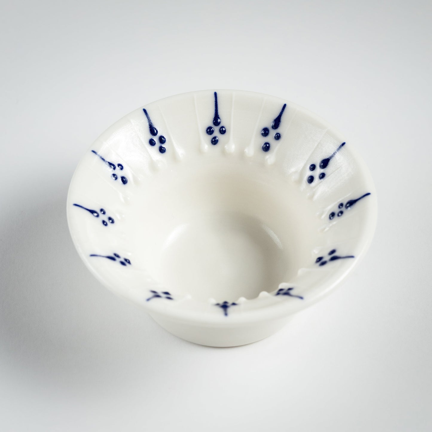 Handmade porcelain tea light holder with flanged rim and blue floral decoration