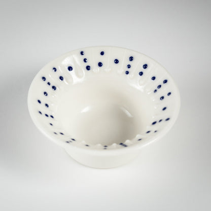 Handmade porcelain tea light holder with flanged rim and blue dotted decoration