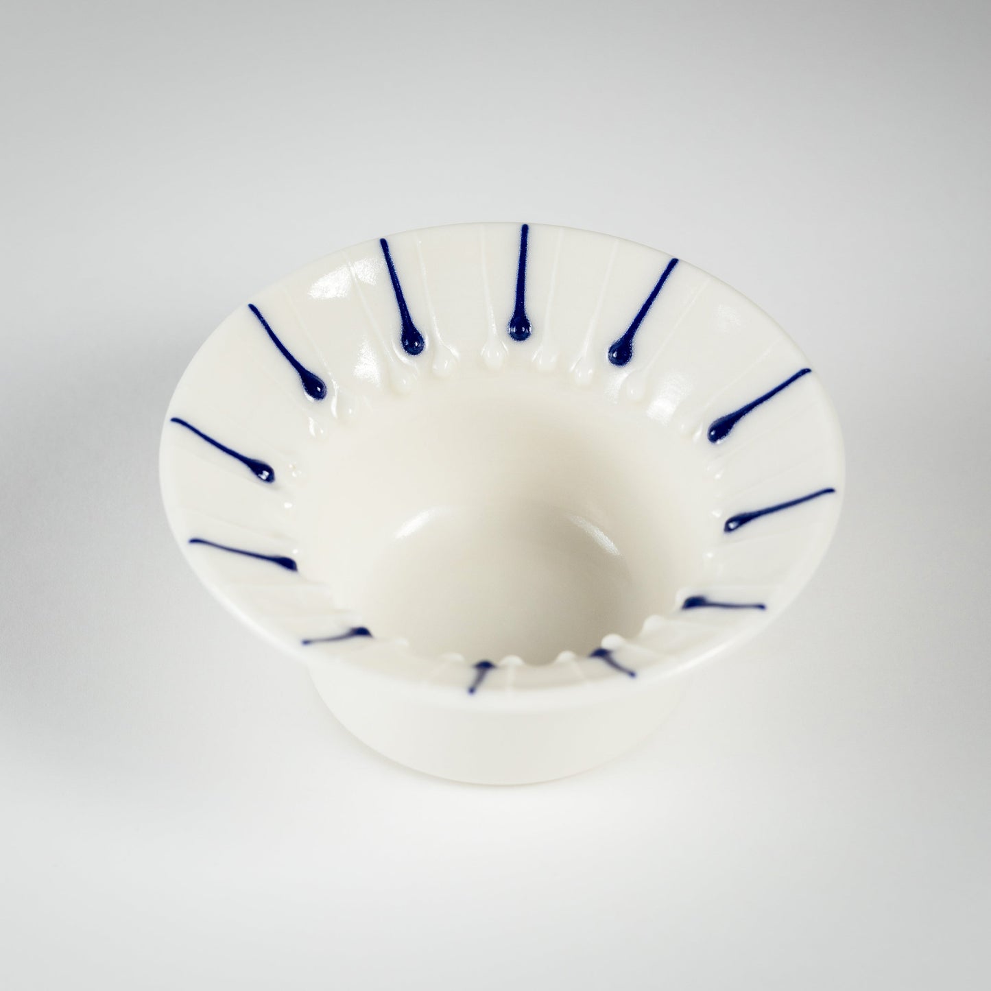 Handmade porcelain tea light holder with flanged rim and blue line decoration