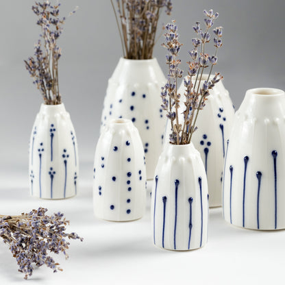 A collection of handmade porcelain mini vases in various blue and white patterns, styled with stems of dried Irish lavender