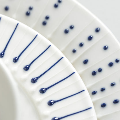 Detail of handmade porcelain side plate with slip-trailed dotted and line patterns