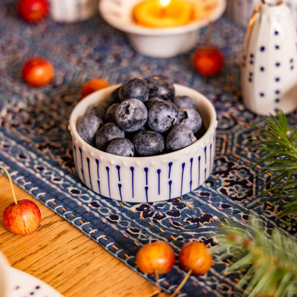 Handmade porcelain ramekin filled with blueberries on a table