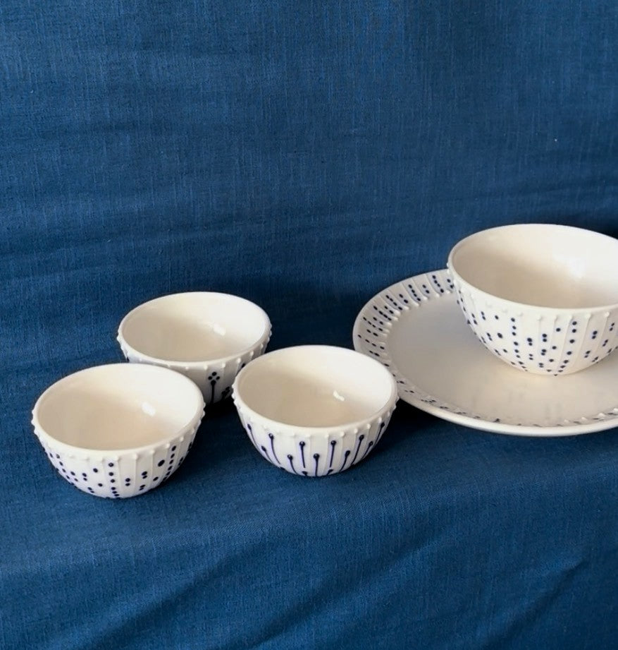 Handmade porcelain mini bowls with blue slip-trailed decoration shown beside a larger breakfast bowl and side plate for scale