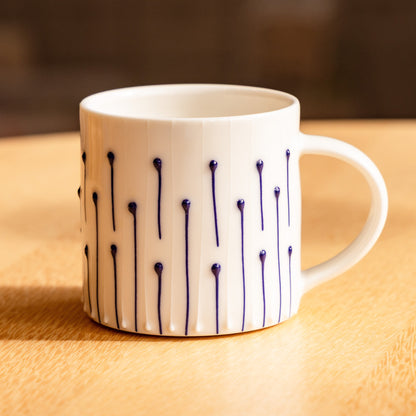 Handmade porcelain coffee mug with blue slip-trailed line decoration