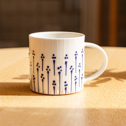 Handmade porcelain coffee mug with blue slip-trailed flower pattern