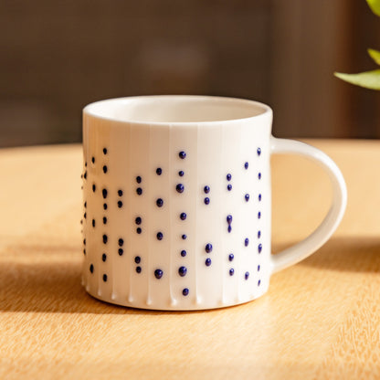 Handmade porcelain coffee mug with blue slip-trailed dot decoration