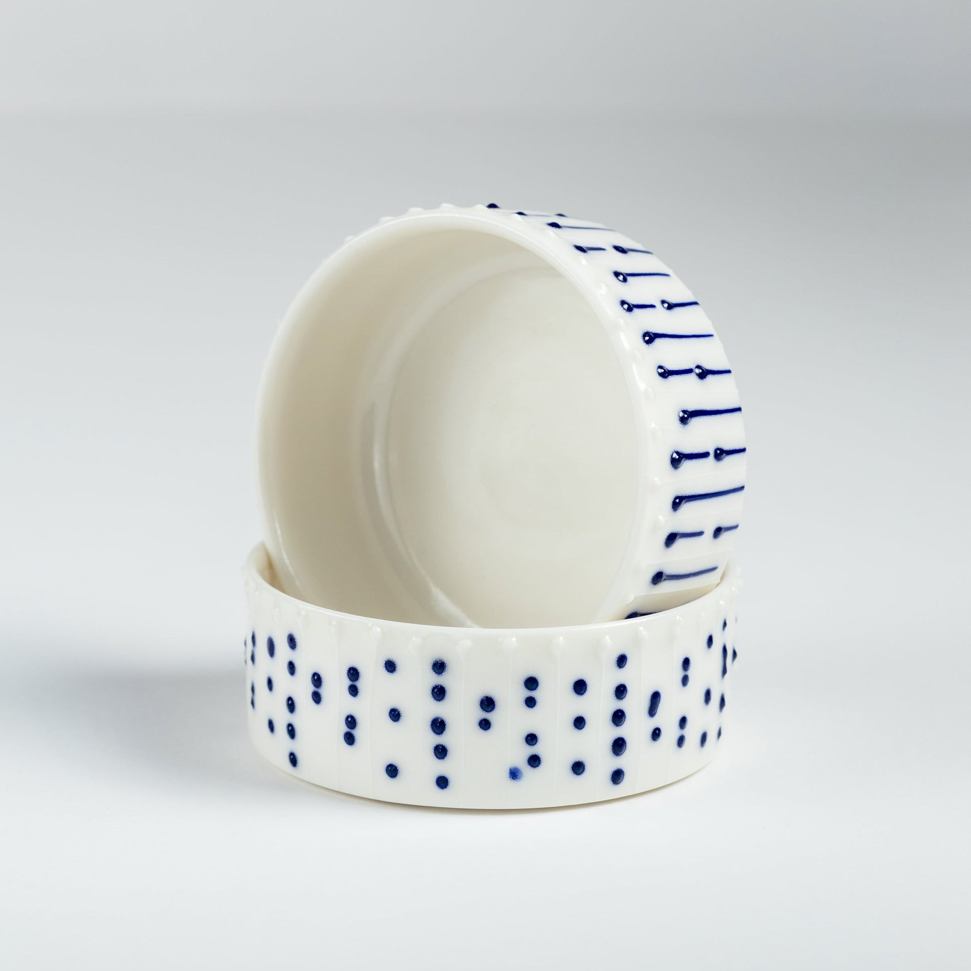 Set of handmade porcelain ramekins with blue slip-trailed decoration