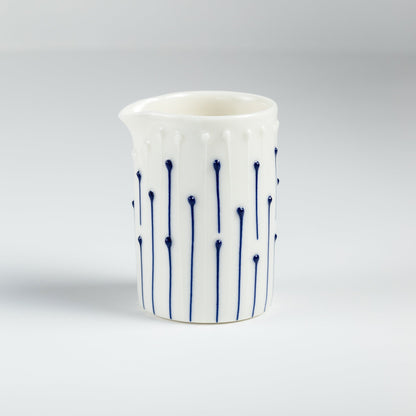 Handmade porcelain milk pourer with blue slip-trailed line decoration