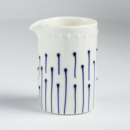 Handmade porcelain milk pourer with blue slip-trailed line pattern