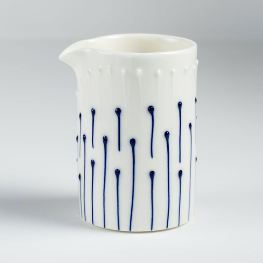 Handmade porcelain milk pourer with blue slip-trailed line pattern